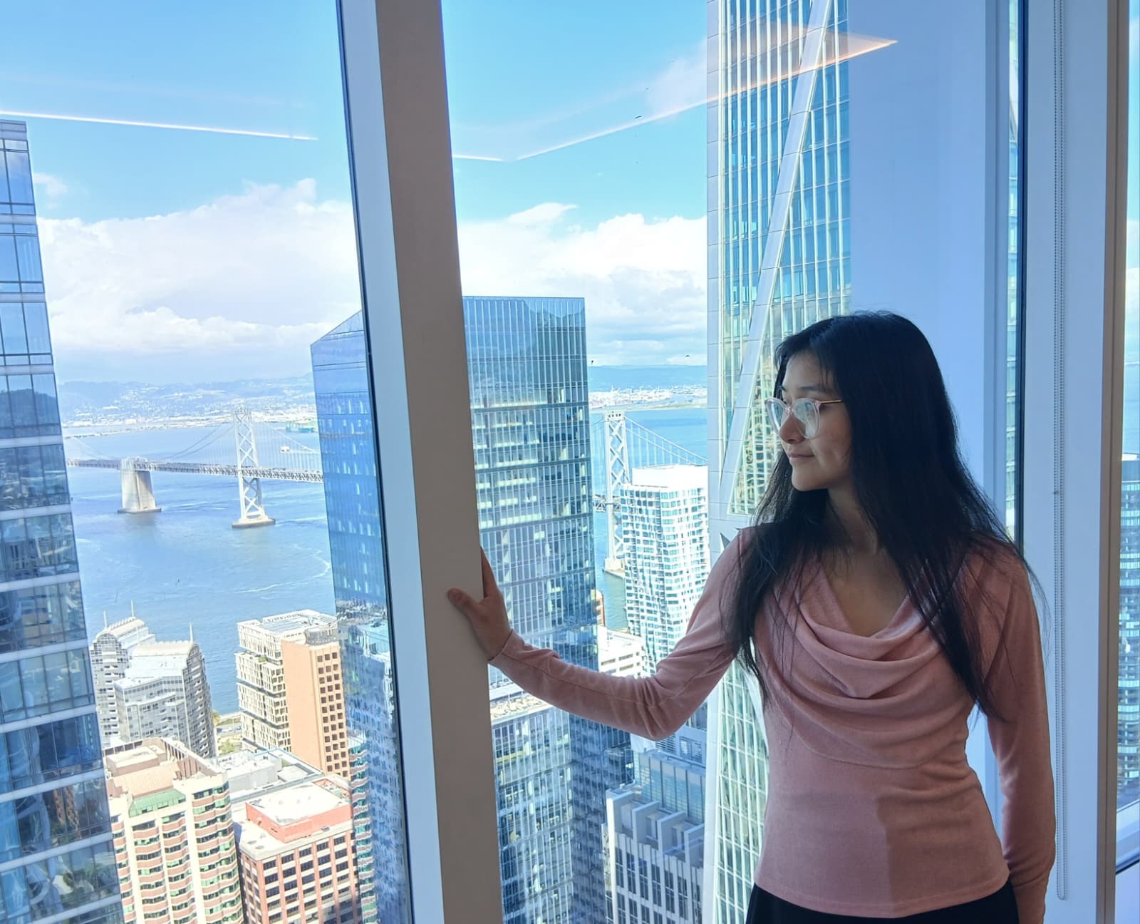 Abigail Briones overlooking San Francisco from a high-rise window
